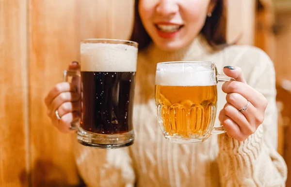 Mujer divertida sosteniendo dos tazas de cerveza en el bar — Foto de Stock
