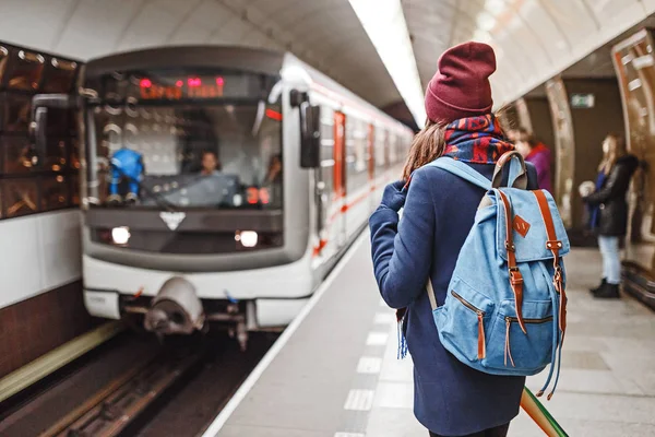 Vista trasera de una mujer mochilera esperando la llegada del tren en metro o metro — Foto de Stock