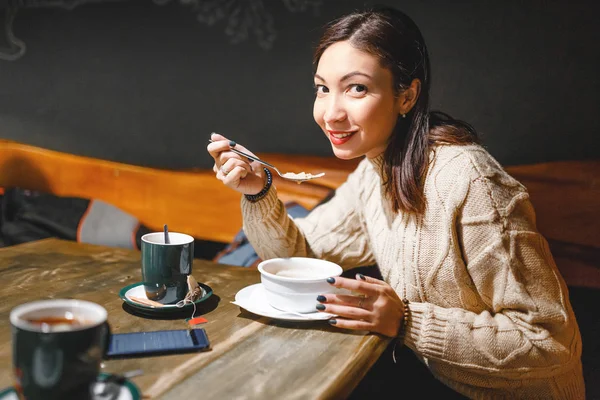 Krásná mladá dívka jíst polévku a pití čaje v restauraci — Stock fotografie