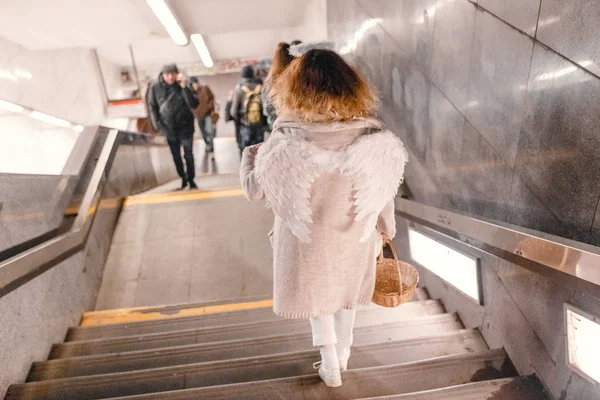 ДЕКАБРЬ 2017, ПРАГА, ЧЕШСКАЯ РЕСПУБЛИКА: Красивая девушка в костюме ангела спускается в метро — стоковое фото
