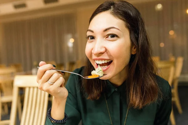 Молода жінка їсть у ресторані — стокове фото