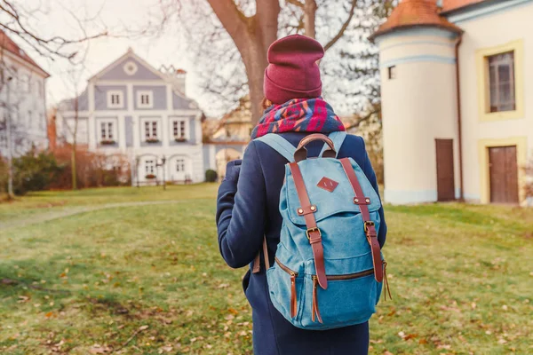 Mulher turista em um casaco com uma mochila viaja nas ruas antigas de Cesky Krumlov — Fotografia de Stock