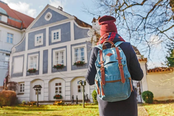 Turistické žena v plášti s batohem cestuje ve staré ulice Český Krumlov — Stock fotografie