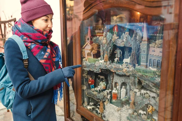 Menina feliz assistir em movimento figuras em miniatura Natal nativivty cena — Fotografia de Stock