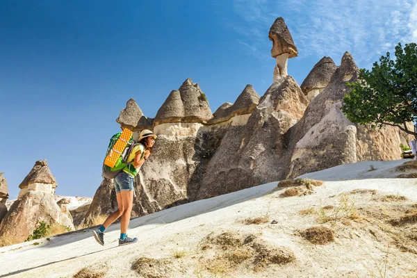Young happy woman traveler alone hiking with backpack in the Pasabag valley of Cappadocia, Turkey — Stock Photo, Image
