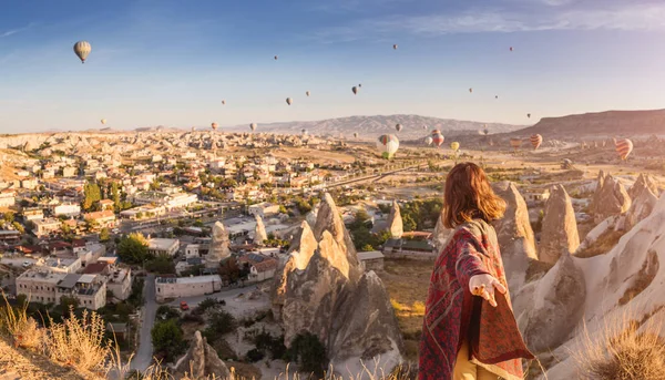 Uma mulher viaja pela Capadócia ao fundo de um grandioso balão na Turquia — Fotografia de Stock