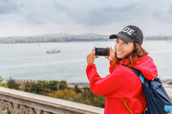 Mujer haciendo foto selfie usando smartphone en invierno en la orilla del mar — Foto de Stock