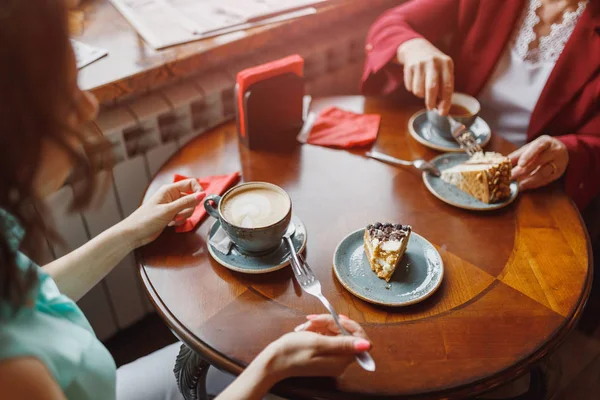 Две женщины болтают в кафе, торт на столе — стоковое фото