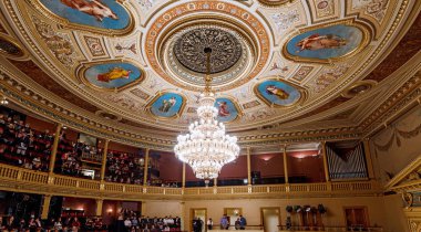 03 DECEMBER 2017, PRAGUE, CZECH REPUBLIC: magnificent chandelier on the ceiling with paintings in National Theater in Prague clipart