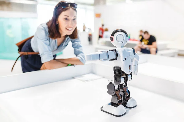 Une étudiante contrôle le travail d'un robot humanoïde intelligent — Photo