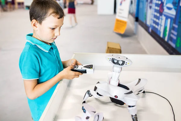 Un garçon construit et joue avec un robot lors d'une exposition de technologies modernes — Photo