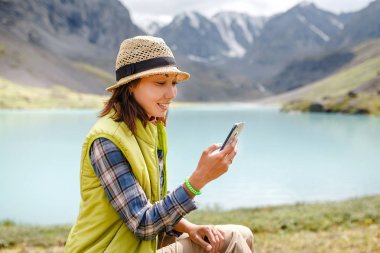 Genç güzel Gezgin kız bir akıllı telefon aracılığıyla dış dünyayla iletişim kurmak için kullandığı