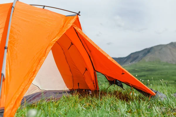 Világos narancs sátor van beállítva, a szép gyep a hegyekben, egy nyugodt, szabadtéri kikapcsolódást fogalma — Stock Fotó