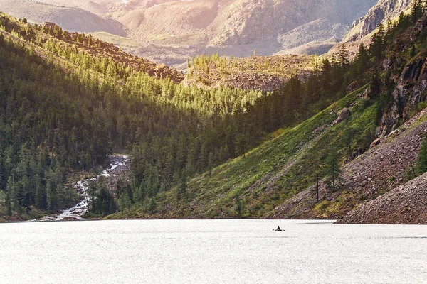 Small Rowing fisherman boat in a huge mountain lake