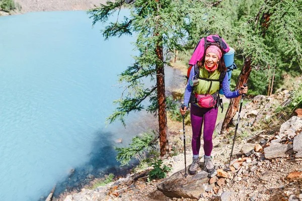Chica excursionista de pie sobre una roca y mirando el lago en las montañas de Altai — Foto de Stock