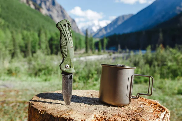 Cup of tea with knife as camping equipment