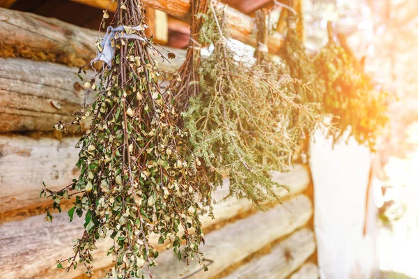 Birch and larch brooms hanging on wooden porch of rural country bath — Stock Photo, Image