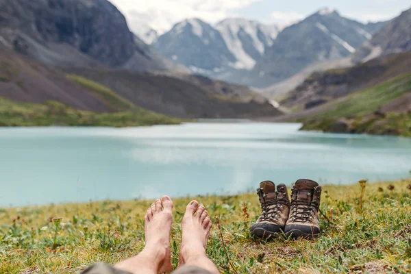 Turista boty stojí na trávníku poblíž jezera v Altaji — Stock fotografie