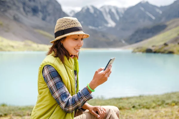 Молода красива дівчина-мандрівник спілкується з зовнішнім світом через смартфон — стокове фото