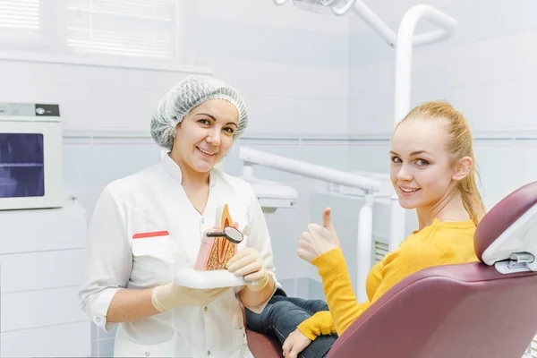 Medico dentista e felice paziente femminile mostrano pollice in alto alla clinica dentale — Foto Stock