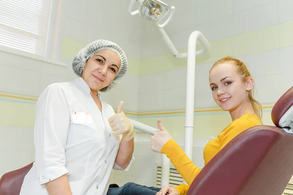 Medico dentista e felice paziente femminile mostrano pollice in alto alla clinica dentale — Foto Stock