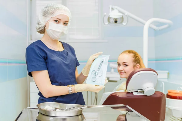 Dentista che tiene una siringa con anestesia vicino a una sedia con un paziente in una clinica dentistica — Foto Stock