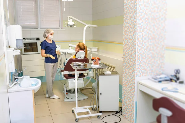 Orvos fogorvos kezeli a beteg nő egy fogászati klinika korszerü berendezéssel — Stock Fotó