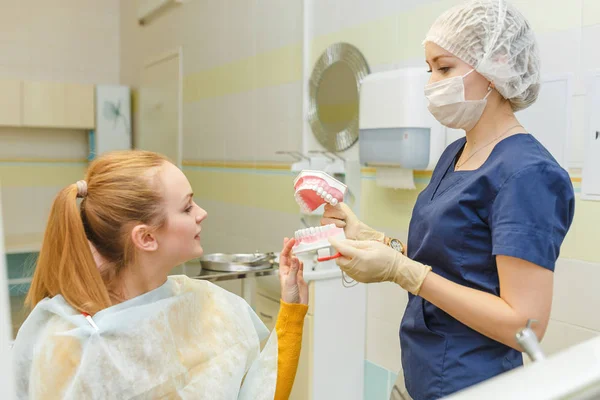 Dentista che mostra un modello di denti e mascella al suo paziente in una clinica di stomatologia — Foto Stock