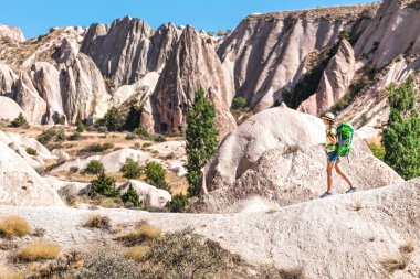Kapadokya Pasabag vadisinde sırt çantası ile genç mutlu kadın gezgin yalnız hiking