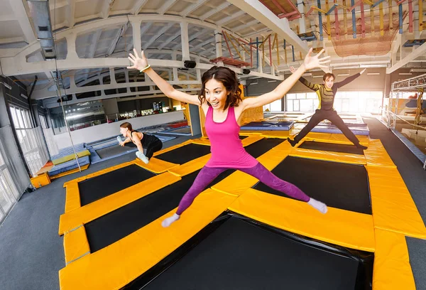 En grupp aktiva vänner hoppande och studsande på en studsmatta, begreppet fitnessanläggning ungdom — Stockfoto