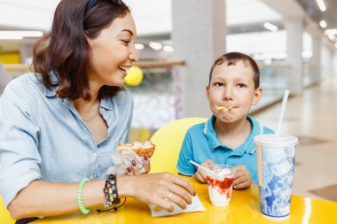 Kadın ve çocuk bir kafede bir fast food yeme