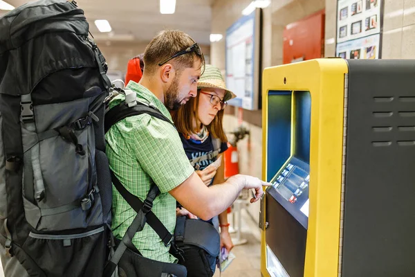 El turista con mochila retira dinero del cajero automático o máquina expendedora de billetes de metro — Foto de Stock