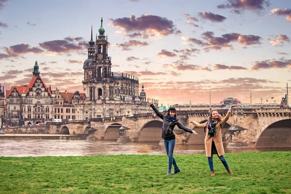 Две очаровательные веселые женщины идут и веселятся вдоль Дрезден-стрит, Германия. Понятие любви и дружбы в путешествиях — стоковое фото