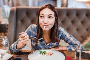 Doğu kadın lüks restoranda çatal ile spagetti makarna yemek
