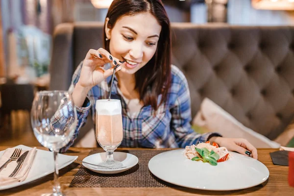 Východní žena jíst špagety těstoviny s vidličkou v luxusní restauraci — Stock fotografie