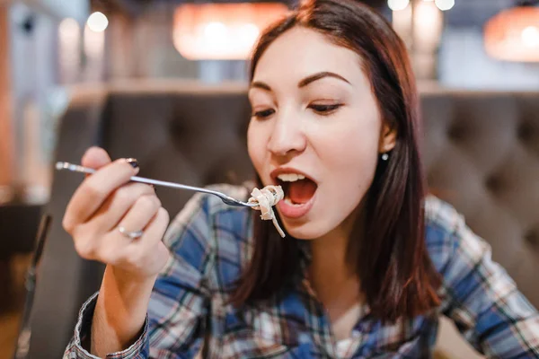Mujer oriental comiendo pasta de espaguetis con tenedor en un restaurante de lujo —  Fotos de Stock