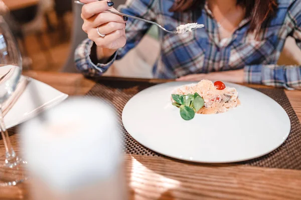 Eastern woman eating spaghetti pasta with fork in luxury restaurant — Stock Photo, Image