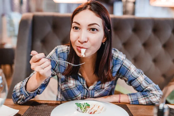 Eastern woman eating spaghetti pasta with fork in luxury restaurant — Stock Photo, Image