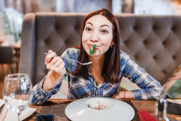 Žena jíst lahodný bylinkový salát s zelení v restauraci — Stock fotografie