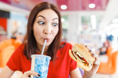 Alışveriş merkezinde Fast food mahkemede burger ile soda içme kadın