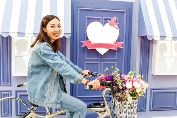 Mujer montando en bicicleta vieja retro colorido con flores en la decoración — Foto de Stock