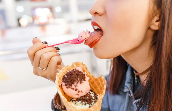 Женщина ест вкусное мороженое в торговом центре после покупок — стоковое фото
