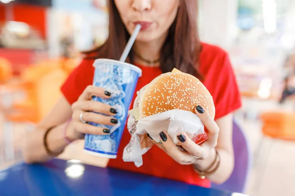 Vrouw drinken van frisdrank met hamburger in fastfood Hof in het winkelcentrum — Stockfoto
