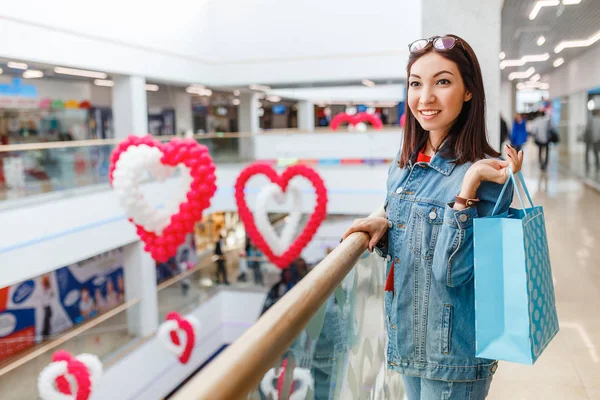 Mujer feliz con bolsa en el centro comercial, regalos, vacaciones y concepto de venta de ropa . —  Fotos de Stock