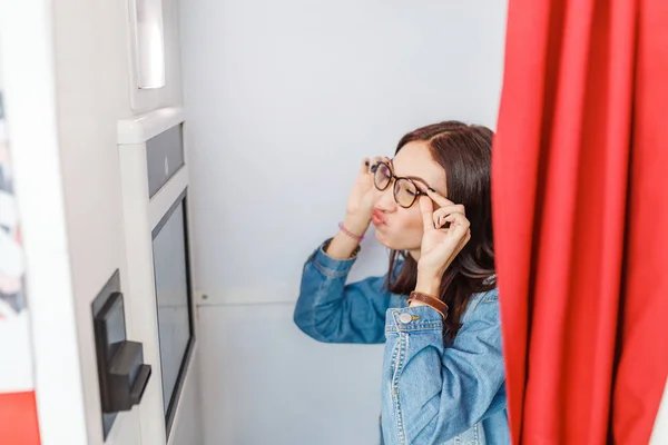 Una mujer es fotografiada y divertida en una cabina de fotos, haciendo fotos de selfies istant para divertirse o para pasaporte y documentos — Foto de Stock