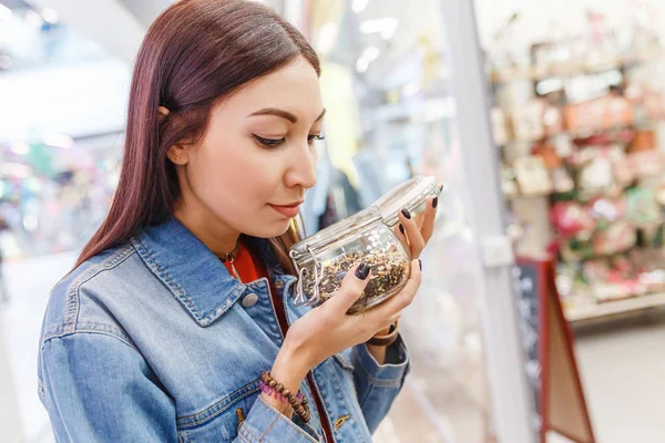 Pozitív nő ügyfél választotta, és illatos, finom íze tea élelmiszer áruház — Stock Fotó