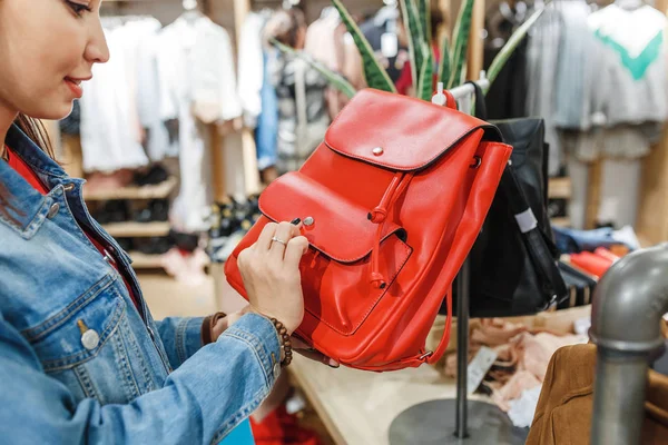 Mujer en la tienda eligiendo bolsas de cuero y mochilas, accesorios de moda y concepto de compras — Foto de Stock