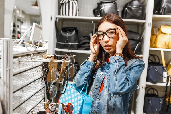 Mujer oriental feliz comprar y elegir gafas de sol con estilo en la tienda en el centro comercial — Foto de Stock