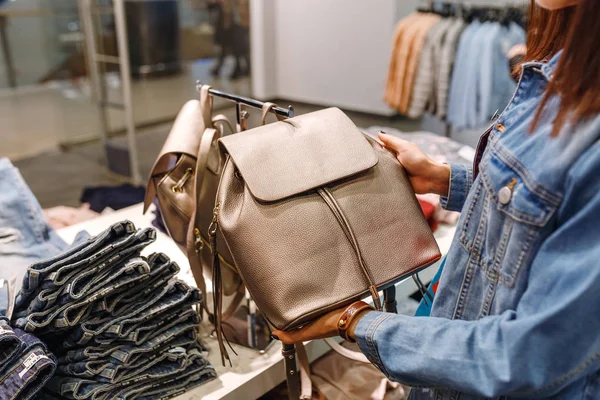Happy woman chooses hand bags while shopping in the mall — Stock Photo, Image