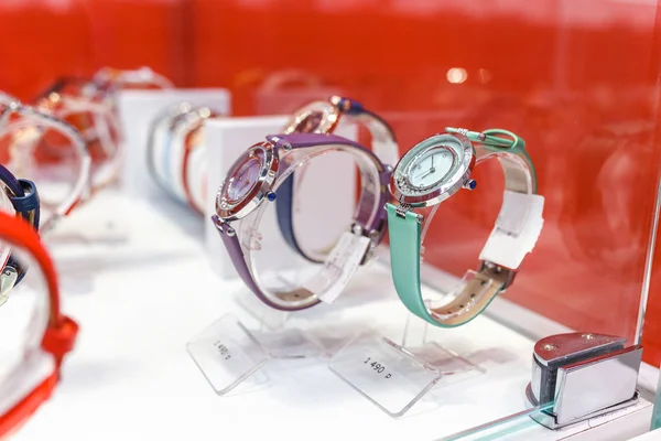 Penceredeki kadın için pek çok renkli kol saatleri mağaza düzeni — Stok fotoğraf